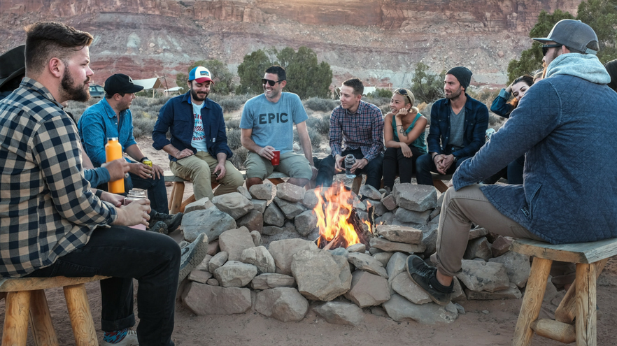 group of people laughing around a fire